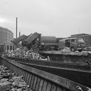 850488 Afbeelding van het storten van huisvuil in vuilnisschuiten in de Biltsche Grift op het Vaaltterrein te Utrecht.